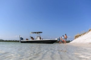 family on beach with boat