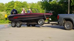 boat on the trailer hooked to truck with people riding